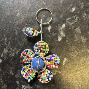 Bright beaded flower with blue ball in the centre key ring